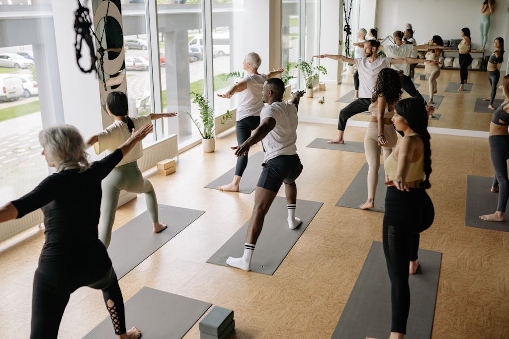 A diverse group of adults practicing yoga indoors, promoting wellness and mindfulness.